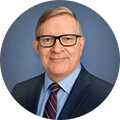 Bret Trimmer from Neograf Solutions in front of a plain blue circular background